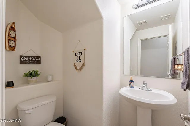 a bathroom with a sink a toilet and mirror