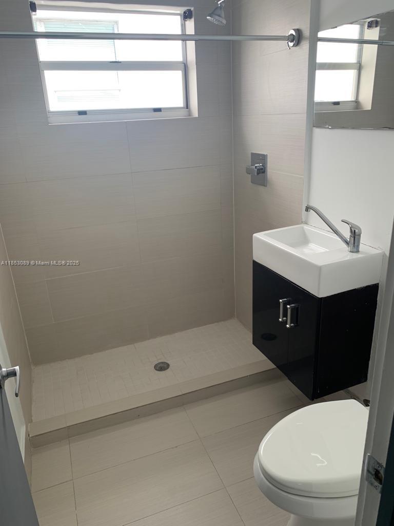 1604 Drexel Avenue, Unit 208 Miami Beach, FL 33139 - Photo 5 of 10 a bathroom with a sink a toilet and shower