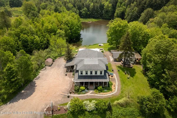 an aerial view of a house with a garden and trees all around
