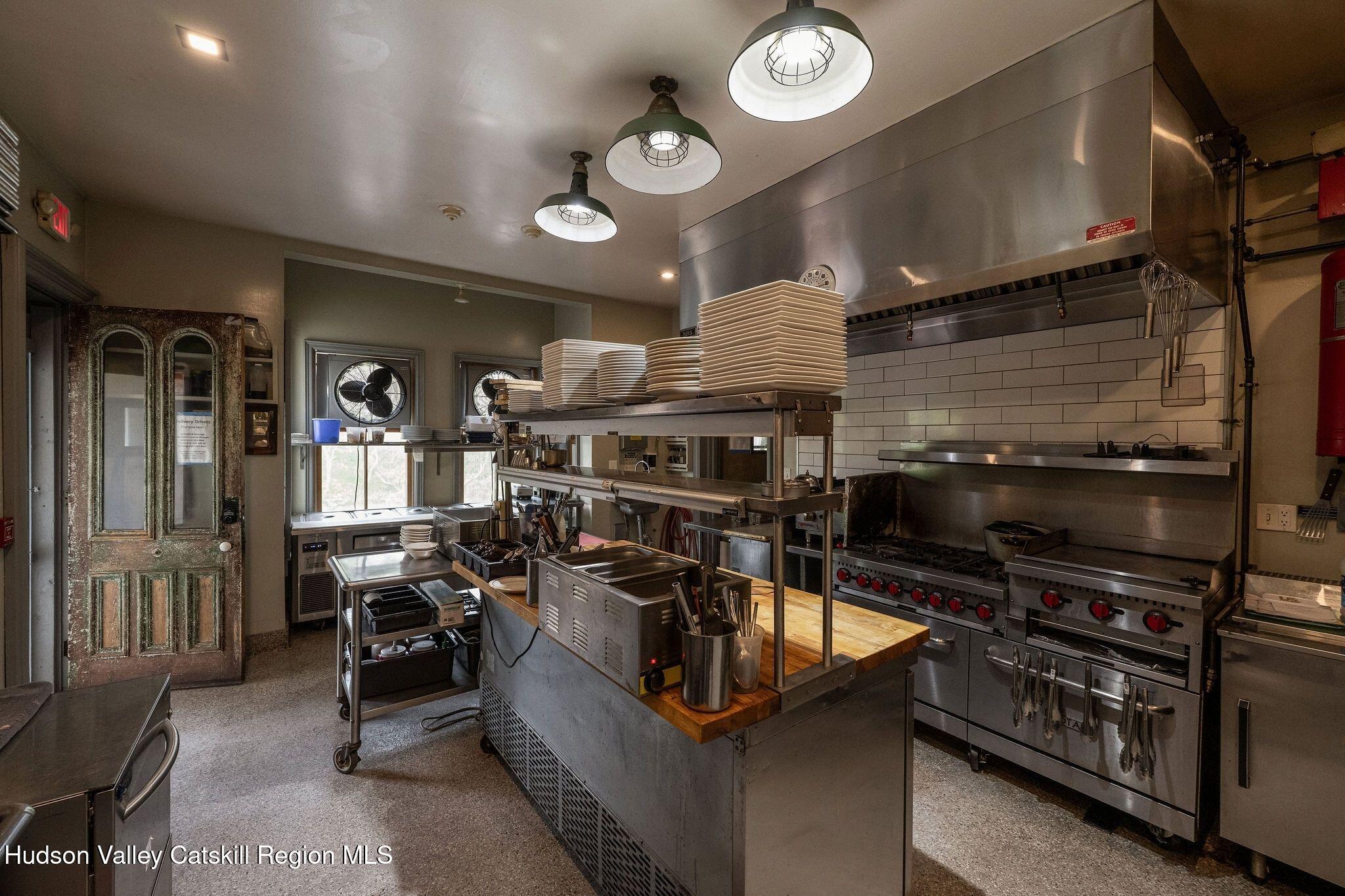 102 Main Street Jefferson, NY 12093 - Photo 27 of 57 a kitchen with stainless steel appliances kitchen island granite countertop a stove a sink and a microwave