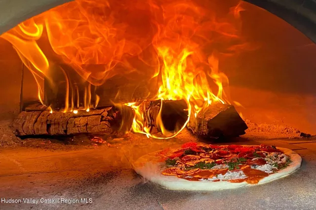 a bedroom with a bed couches chair and three windows