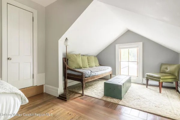 a view of a bedroom with wooden floor and cabinet