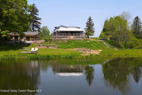 a view of a house with a yard and a pond