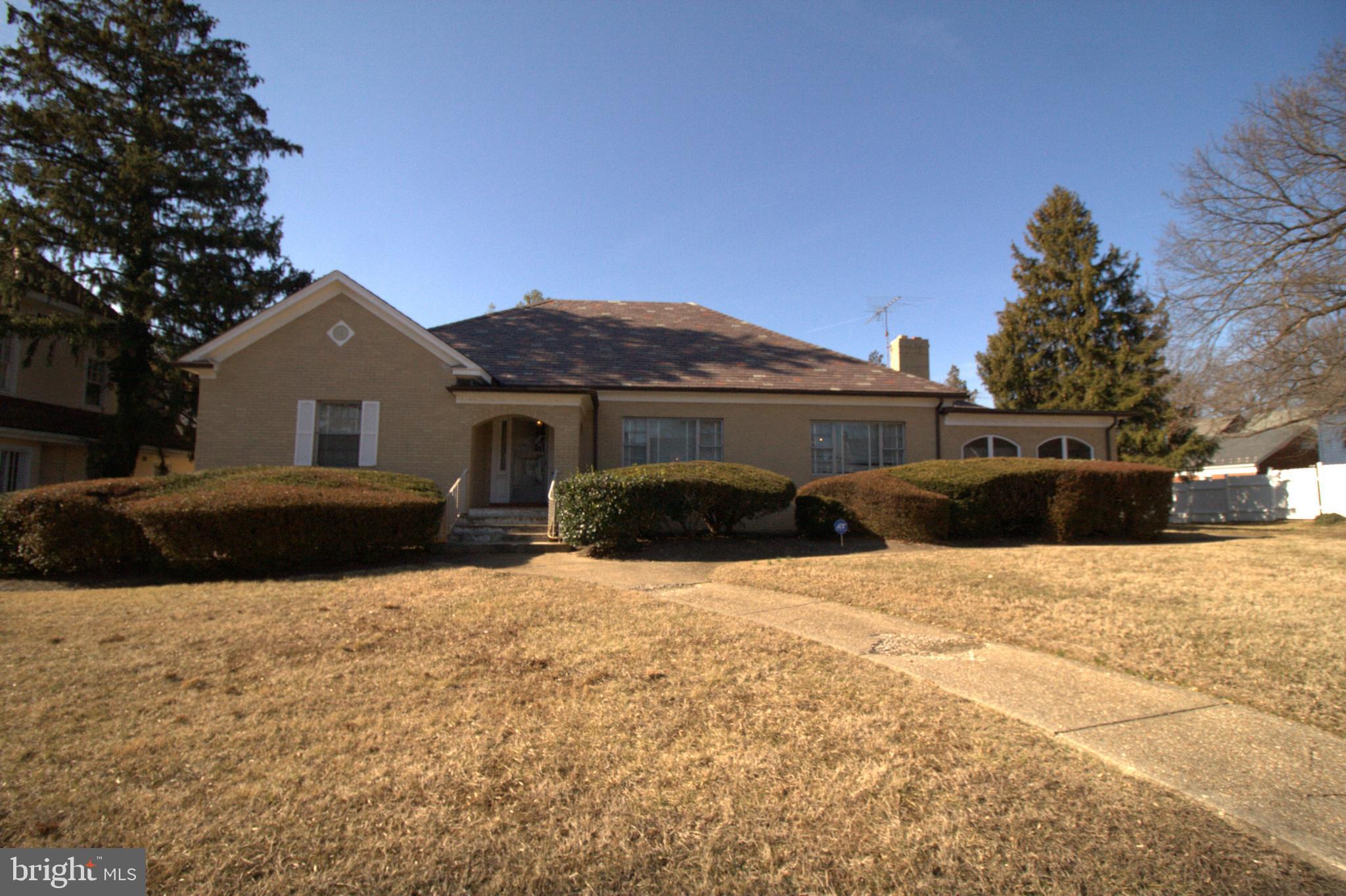 a front view of a house with a yard covered with snow in front of house
