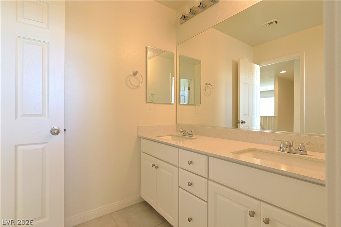 8663 Reynolds Spring Street Las Vegas, NV 89178 - Photo 29 of 32 Clean lines and a spacious dual vanity define this functional bathroom space.