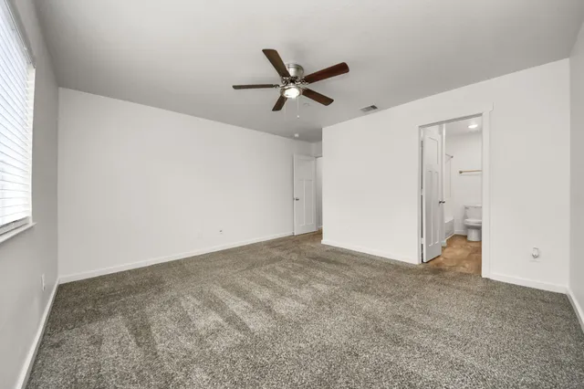 an empty room with closet and windows