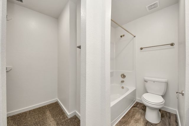 a white toilet sitting next to a bathtub