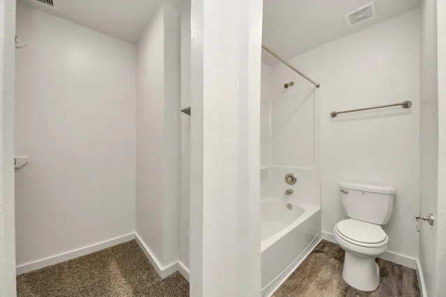 a white toilet sitting next to a bathtub