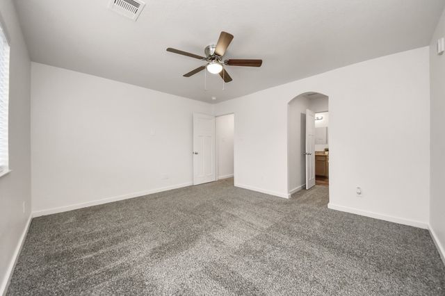 an empty room with ceiling fan and window