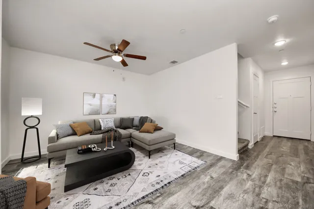 a living room with furniture and a ceiling fan
