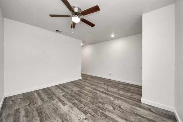 an empty room with a ceiling fan and a window