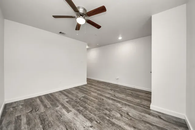 an empty room with a ceiling fan and a window