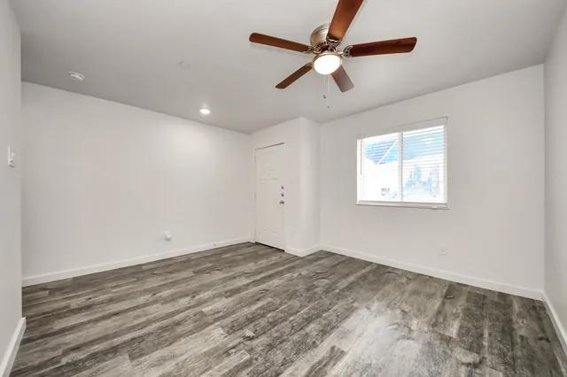 an empty room with a window and a ceiling fan