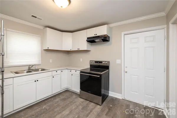 a kitchen with stainless steel appliances a sink stove and cabinets