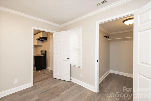 a view of a hallway with wooden floor and closet