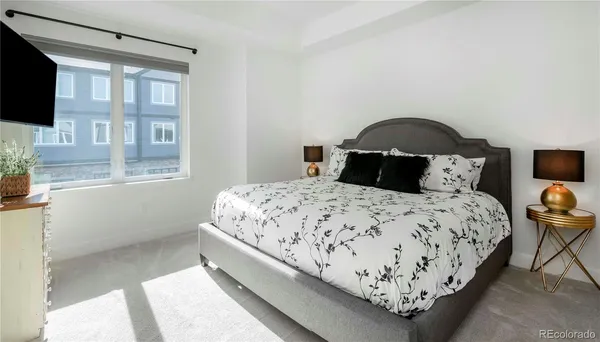 a bedroom with a bed and a flat tv screen on the dresser