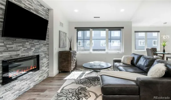 a living room with furniture a fireplace and a flat screen tv