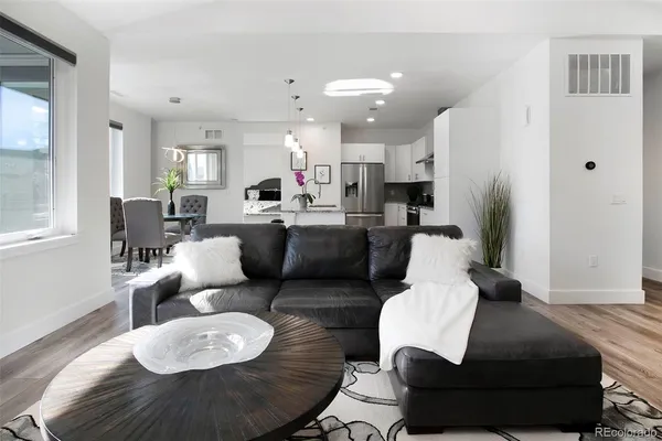 a living room with furniture and a wooden floor