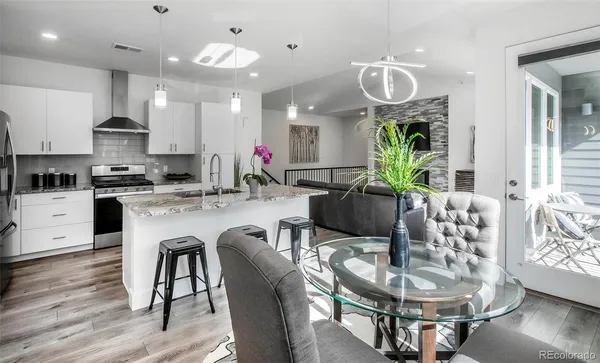 a kitchen with granite countertop a dining table chairs and kitchen view with wooden floor
