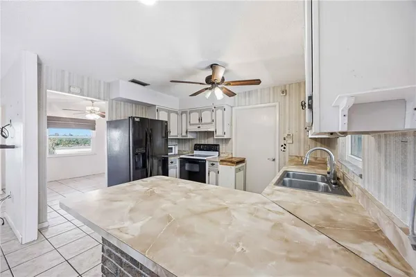 a kitchen with stainless steel appliances kitchen island sink refrigerator and stove