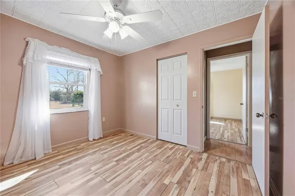 a view of empty room with window and ceiling fan