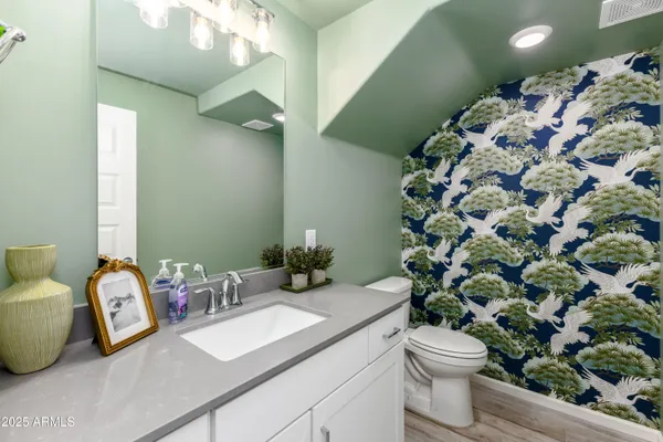 a bathroom with a sink a toilet and a mirror