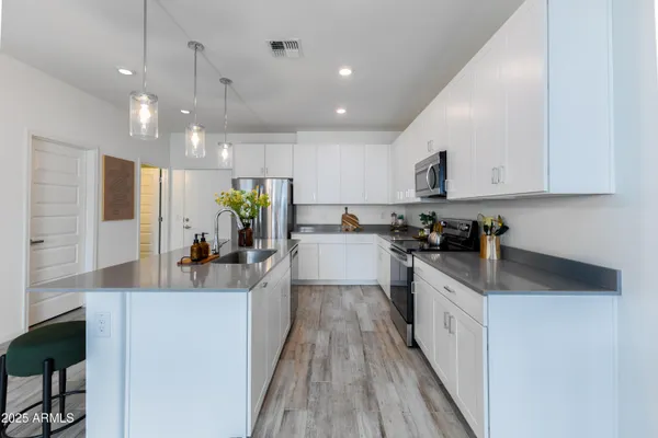 a kitchen with counter top space a sink cabinets and stainless steel appliances
