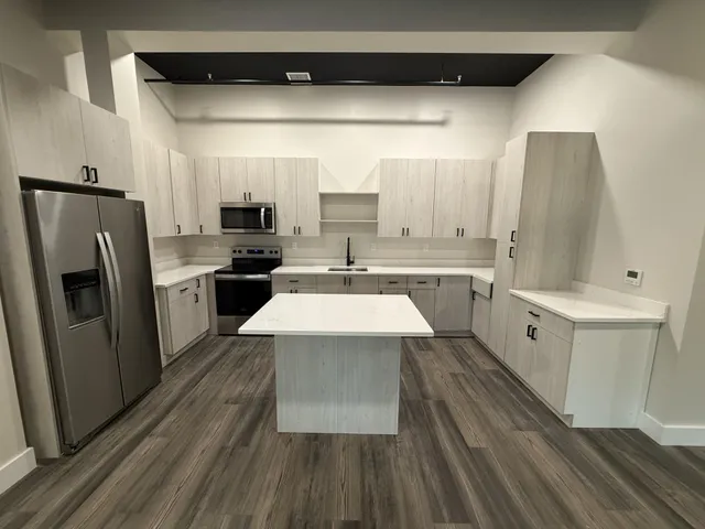 a large kitchen with a sink and refrigerator