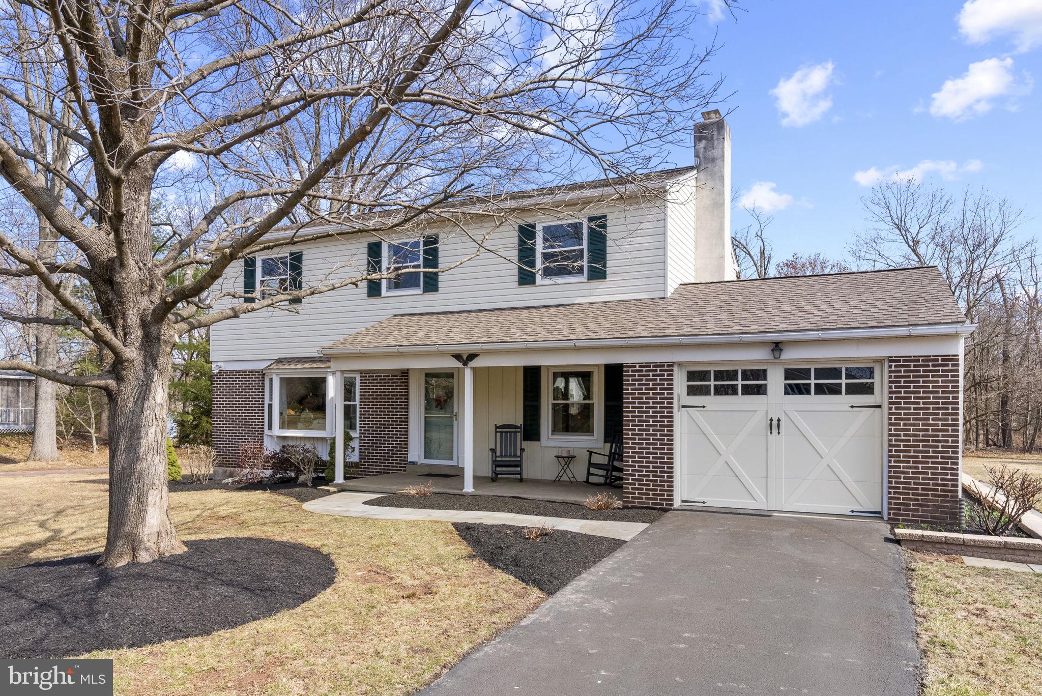 a front view of a house with garden and parking