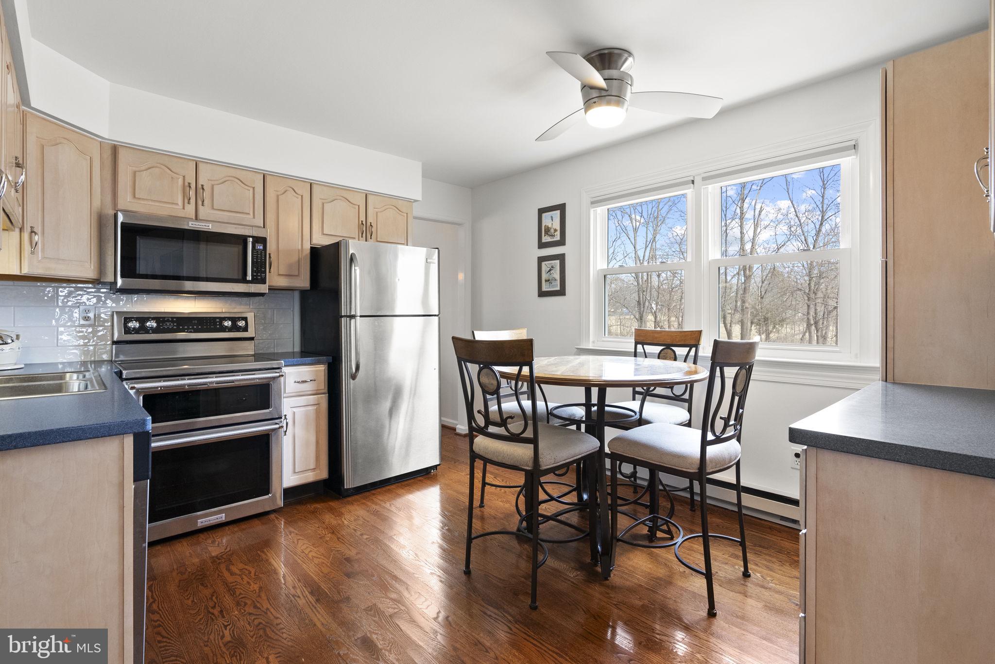 222 Brookside Circle Harleysville, PA 19438 - Photo 10 of 34 a kitchen with stainless steel appliances a dining table chairs stove refrigerator and microwave