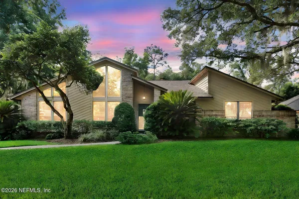 a view of a dining room with furniture large windows and wooden floor
