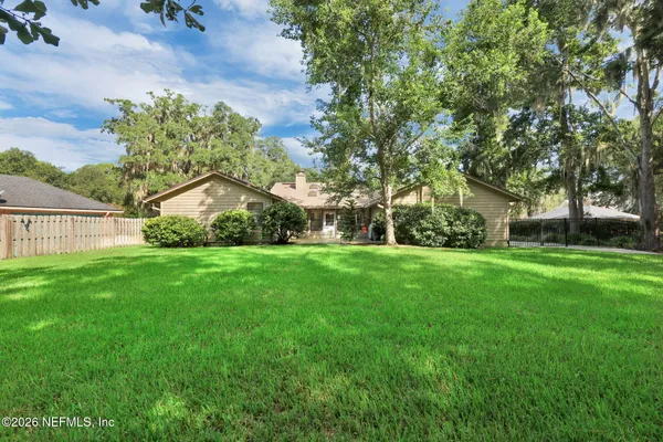 a front view of a house with a yard and potted plants