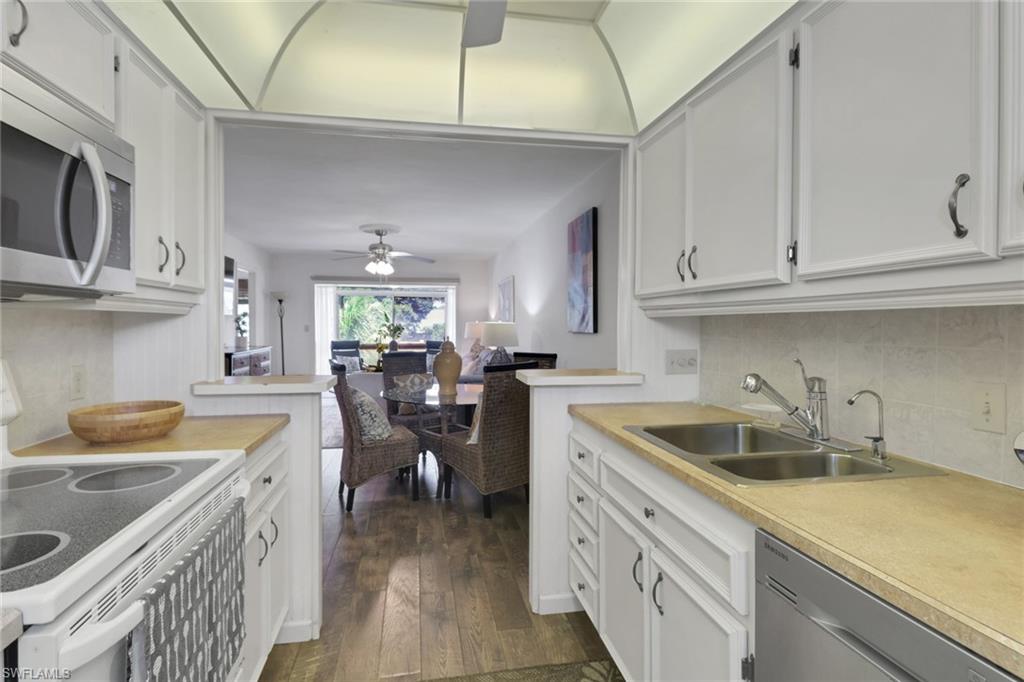 1021 3rd Street South, Unit 306 Naples, FL 34102 - Photo 12 of 24 a kitchen with cabinets and stainless steel appliances
