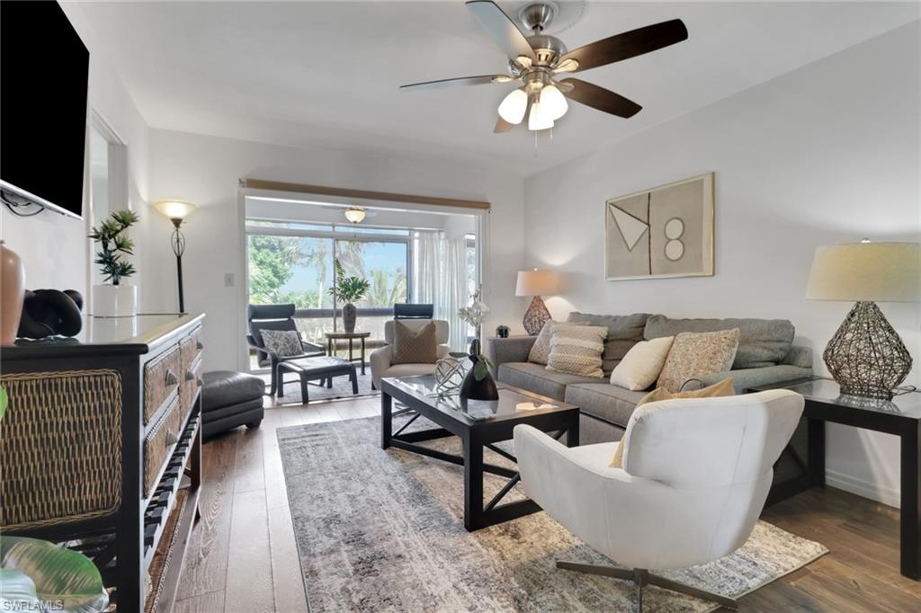 1021 3rd Street South, Unit 306 Naples, FL 34102 - Photo 16 of 24 a living room with furniture a flat screen tv and a large window