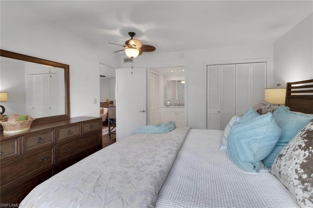 1021 3rd Street South, Unit 306 Naples, FL 34102 - Photo 19 of 24 a bedroom with a bed and a chandelier