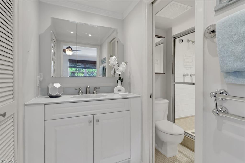 1021 3rd Street South, Unit 306 Naples, FL 34102 - Photo 20 of 24 a bathroom with a toilet a sink a tub and mirror