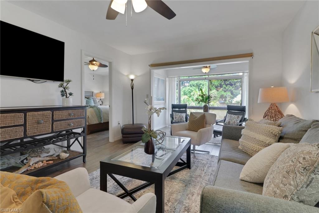 1021 3rd Street South, Unit 306 Naples, FL 34102 - Photo 2 of 24 a living room with furniture and a flat screen tv