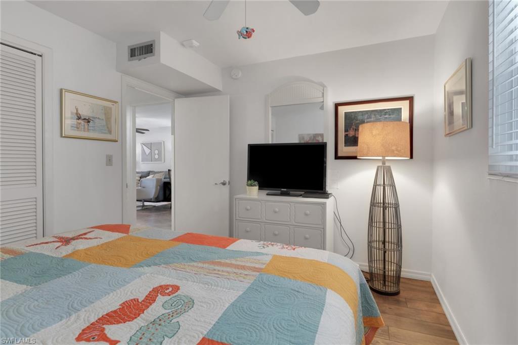 1021 3rd Street South, Unit 306 Naples, FL 34102 - Photo 22 of 24 a bedroom with a bed and a flat screen tv
