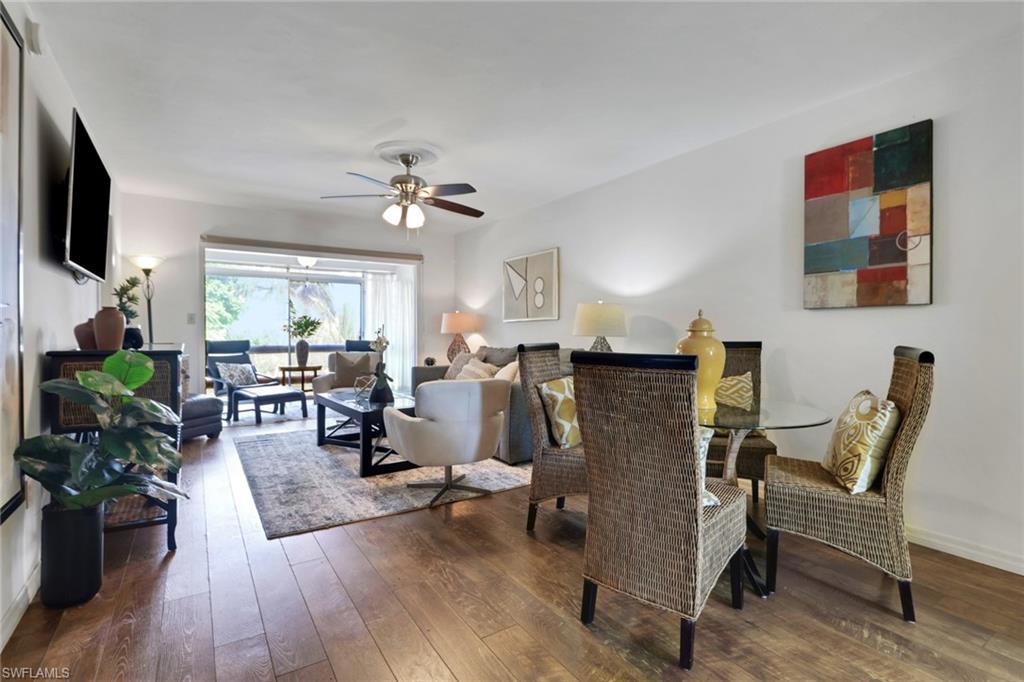 1021 3rd Street South, Unit 306 Naples, FL 34102 - Photo 6 of 24 a living room with furniture a flat screen tv and a fireplace