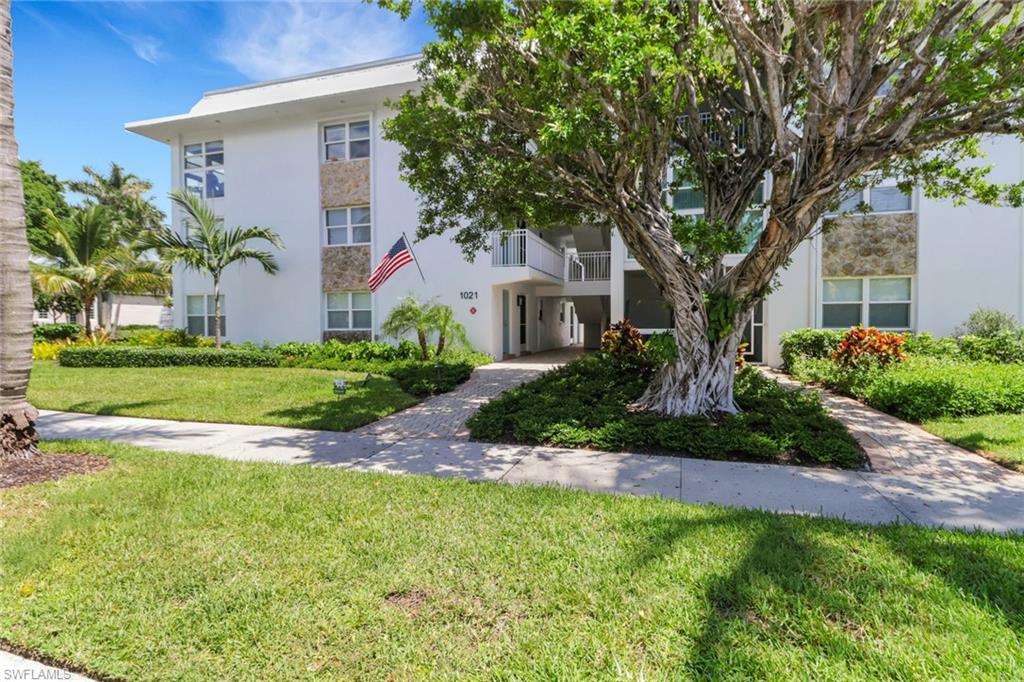 1021 3rd Street South, Unit 306 Naples, FL 34102 - Photo 8 of 24 a front view of a house with a yard and potted plants