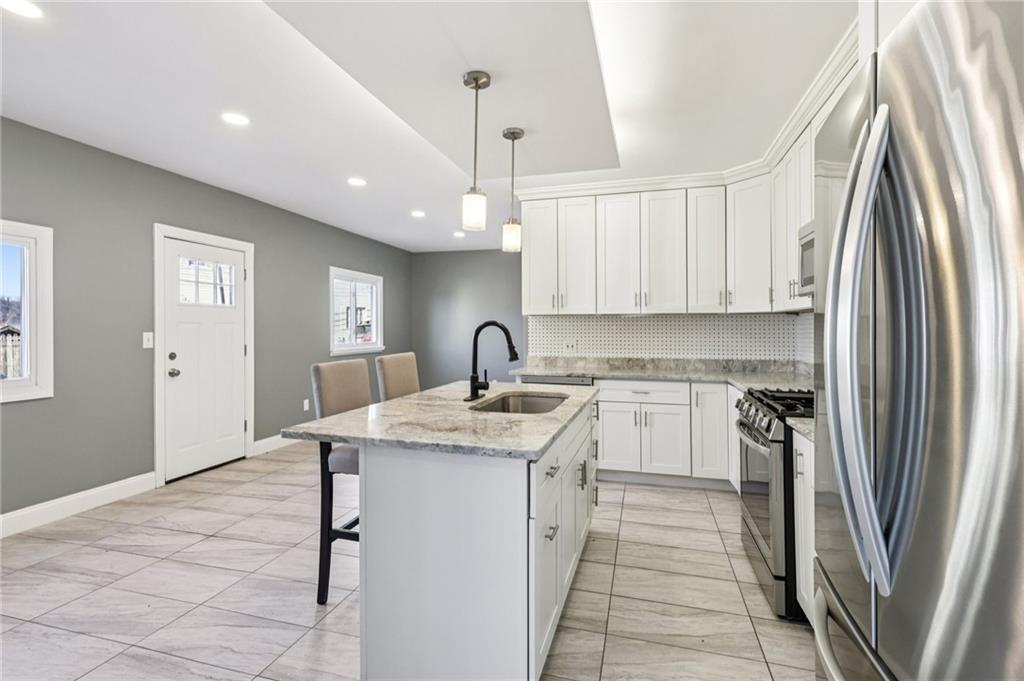 5256 Wickliff Street Pittsburgh, PA 15201 - Photo 14 of 49 a kitchen with stainless steel appliances granite countertop a sink refrigerator and cabinets