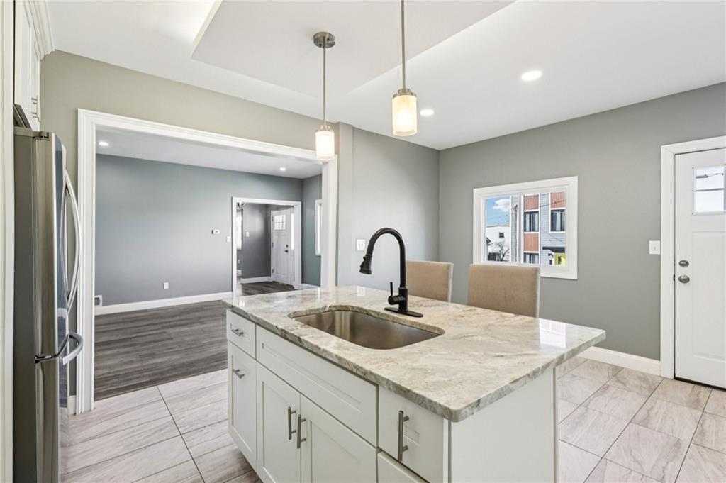 5256 Wickliff Street Pittsburgh, PA 15201 - Photo 15 of 49 a kitchen with a sink a counter and living room view