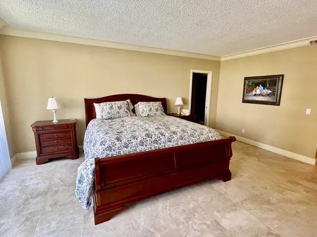 a bedroom with a bed dresser and a wall painting