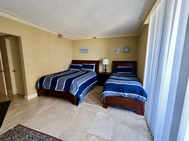 a bedroom with a bed and a dresser next to a window