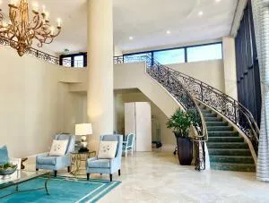 a view of a patio with table and chairs potted plants and floor to ceiling window