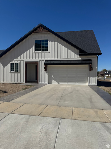 389 West 2100 South Perry, UT 84302 - Photo 10 of 21 White vertical siding exterior with dark-shingled roof and integrated two-car garage