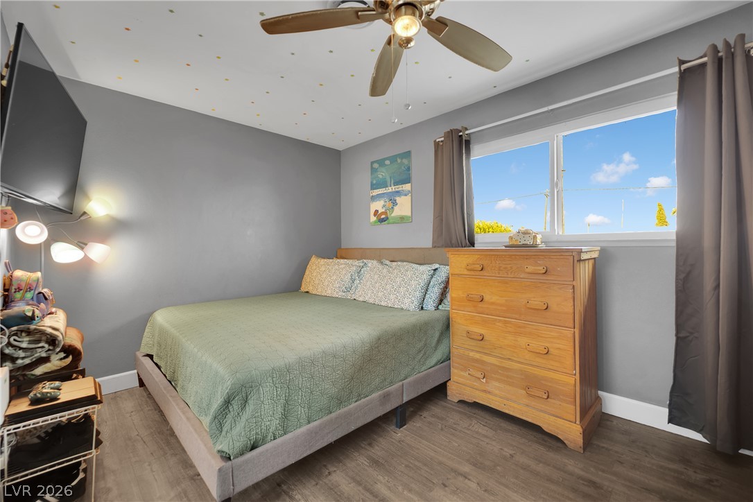 2221 Englestad Street North Las Vegas, NV 89030 - Photo 16 of 32 Well-lit sleeping quarters with rich wood-toned flooring and a spacious window for natural light.