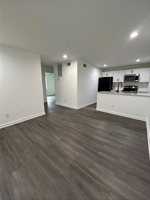 321 East 8th Street, Unit 111 Dallas, TX 75203 - Photo 1 of 1 Open-concept living area with dark wood-finish flooring