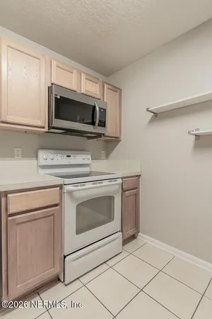 an empty room with windows and ceiling fan