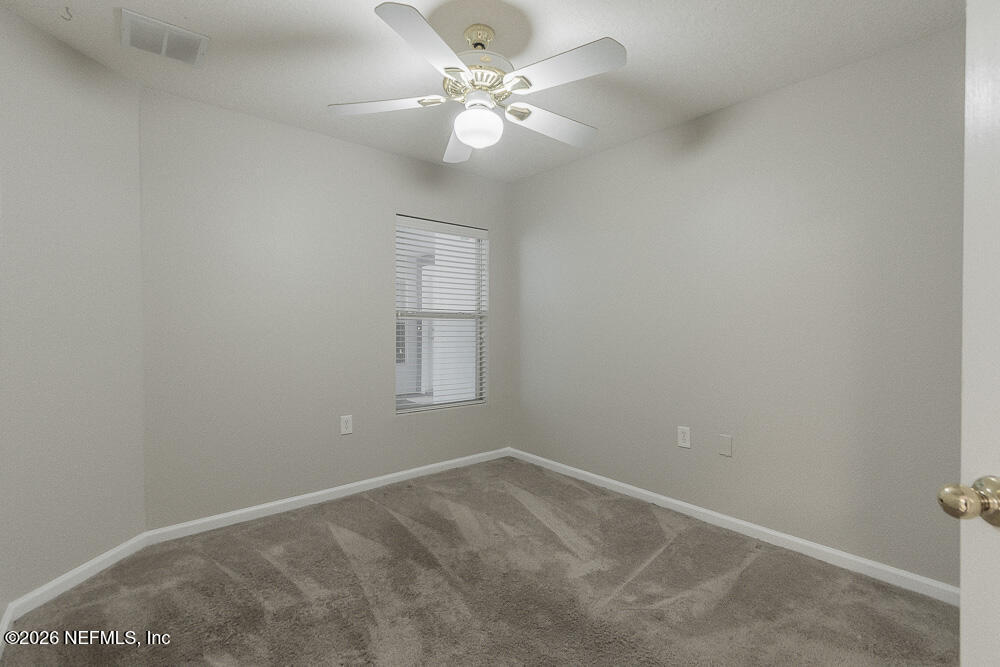 7920 Merrill Road, Unit 1511 Jacksonville, FL 32277 - Photo 17 of 32 an empty room with windows and ceiling fan
